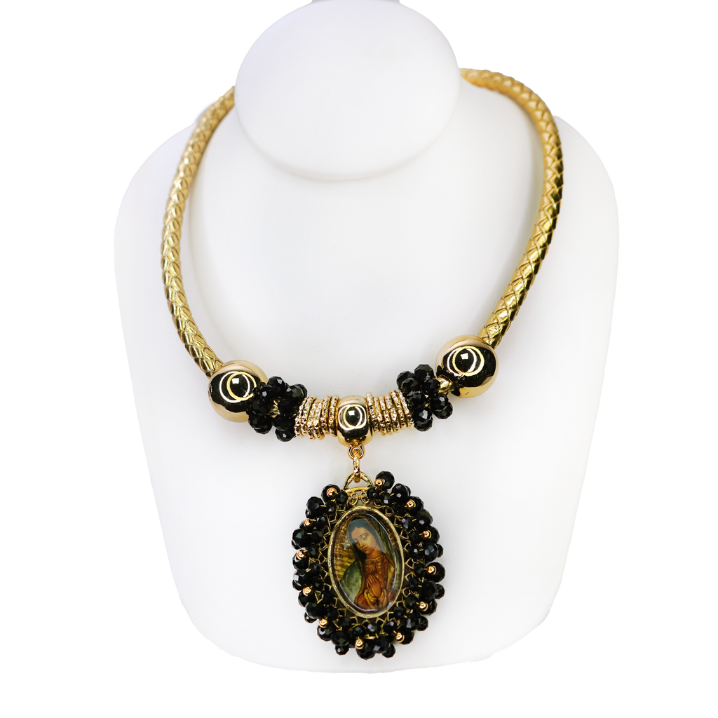 Gold and black beaded necklace with a pendant on a white mannequin bust.