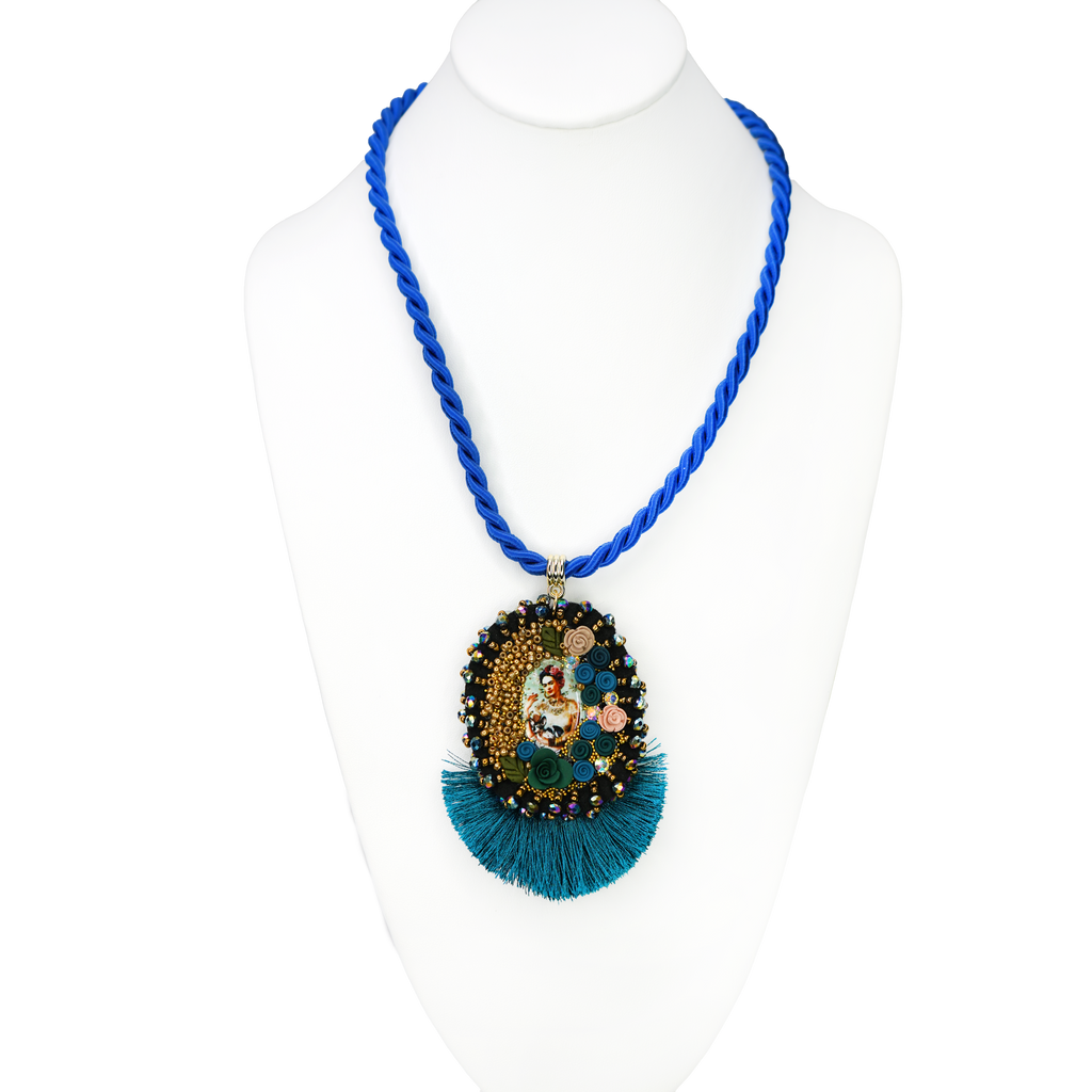Blue beaded necklace with a decorative pendant on a mannequin.